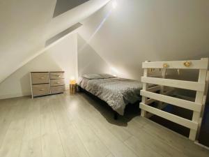 a bedroom with a bed and a dresser in a attic at Le Cosy bohème Abbeville baie de Somme in Abbeville