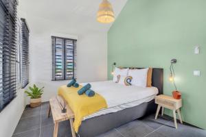 a bedroom with a bed with a yellow blanket at Brand new Two Bedroom Apartment at the Water in Kralendijk