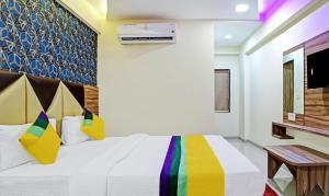 um quarto de hotel com uma cama e uma televisão em Itsy By Treebo - Rk Palace em Vadodara