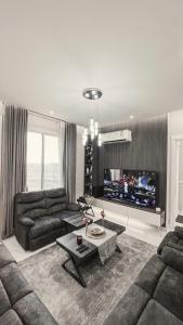 salon z kanapą i telewizorem w obiekcie سيلينا هاوس w mieście Dżudda