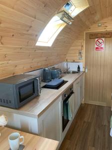 a kitchen with a counter with a microwave and a sink at Loch an Eilean Pod Isle of South Uist in Pollachar