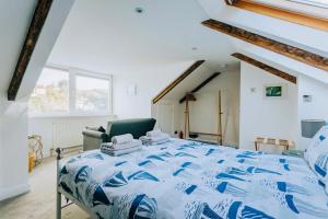 a bedroom with a blue bed and a chair at The Slipway Fowey Harbour Parking 1 Min & Garden in Fowey
