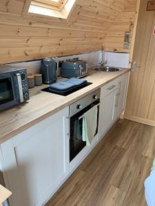 a kitchen with a microwave and a sink in a cabin at Loch an Eilean Pod Isle of South Uist in Pollachar