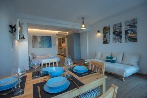ein Wohnzimmer mit einem Tisch mit blauen Gerichten darauf in der Unterkunft Ammos Lux Apartments Crete in Agios Nikolaos