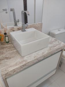 lavandino bianco in bagno con servizi igienici di Residencial Maristela a Bombinhas