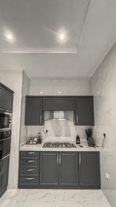 a kitchen with black cabinets and a stove top oven at سيلينا هاوس in Jeddah