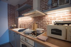 eine Küche mit einer Backsteinwand und einer Theke mit einer Mikrowelle in der Unterkunft Ammos Lux Apartments Crete in Agios Nikolaos