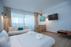 ein Hotelzimmer mit 2 Betten und einem Sofa in der Unterkunft Ammos Lux Apartments Crete in Agios Nikolaos