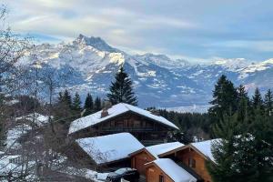 a ski lodge with snow covered mountains in the background at Apartment with stunning view! Ski-in, ski-out in Villars-sur-Ollon