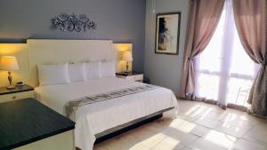 a bedroom with a white bed and two windows at Combate Beach Resort in Cabo Rojo