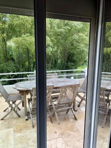 einen Tisch und Stühle auf einer Terrasse mit Waldblick in der Unterkunft Maison familiale in Sauve