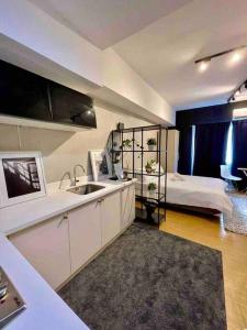 Il comprend une cuisine avec un évier et une chambre avec un lit. dans l'établissement Modern Brand New Condo in Grace Residence Taguig, à Manille