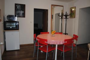 einem Esstisch mit roten Stühlen und einer Mikrowelle in der Unterkunft Apartmán Štěpánka in Jihlava