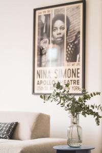 een vaas op een tafel in een woonkamer met een foto bij Snoring Bastards in Oostende