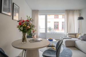 un soggiorno con tavolo e vaso di fiori di Snoring Bastards a Ostenda