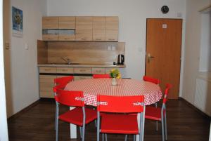 a kitchen with a table and red chairs at Apartmán Štěpánka in Jihlava