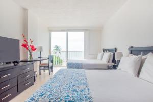 a hotel room with two beds and a television at Blu Hotel by Tamaca in Santa Marta