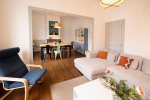 ein Wohnzimmer mit 2 Sofas und einem Esszimmer in der Unterkunft Le Familial - Tout équipé - Proche centre in Montluçon + 16 Fotos