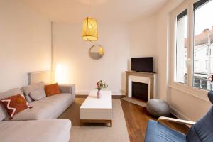 ein Wohnzimmer mit Sofa und Kamin in der Unterkunft Le Familial - Tout équipé - Proche centre in Montluçon