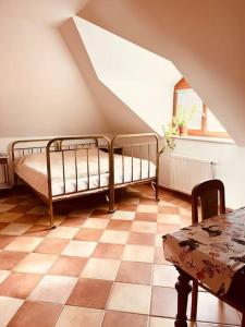 un dormitorio con 2 camas y una mesa en un ático en Apartmán se zahradou 20 minut do centra Prahy, en Ořech
