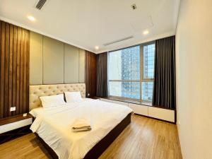a bedroom with a large bed and a large window at The Landmark Vinhomes-Service Apartment in Ho Chi Minh City