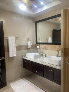a bathroom with two sinks and a large mirror at Placencia Pointe Townhomes #5 in Placencia Village