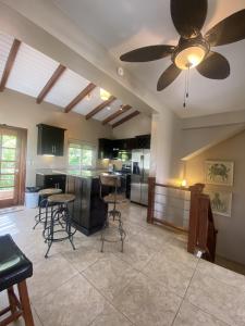 a living room with a ceiling fan and a kitchen at Placencia Pointe Townhomes #5 in Placencia Village