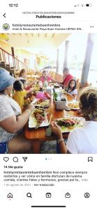 a group of people sitting at a table eating food at Buen Hombre kite Hotel y restaurante in Villa Vásquez