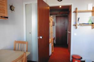 a hallway with a door and a room with a table at studio à Risoul 1850 m in Risoul