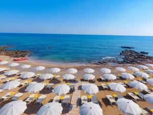 una vista aérea de una playa con sombrillas blancas en Dimora Antonella - Ostuni 4 seasons - Splendid Villa Depandance with Private Swimming Pool, en Ostuni