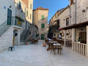 an alley with tables and chairs in an old building at Residence Bella in Stari Grad
