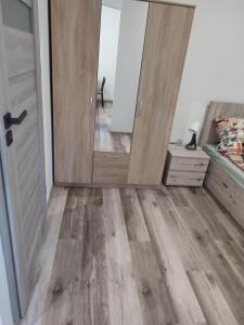 a bedroom with a wooden floor and a door at Szare Miraże in Busko-Zdrój +9 photos