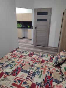 a bedroom with a bed with a quilt on it at Szare Miraże in Busko-Zdrój