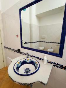 ein Bad mit einem Waschbecken und einem Spiegel in der Unterkunft Pan Di Zucchero in Nebida