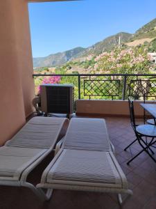 einen Balkon mit 2 Betten sowie einem Tisch und Stühlen in der Unterkunft Pan Di Zucchero in Nebida