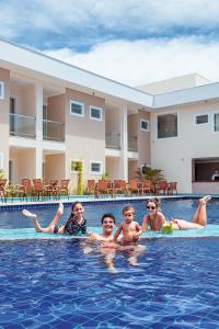 un grupo de niños en la piscina de un hotel en Orquídeas Praia Hotel, en Porto Seguro