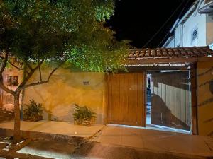 a house with a wooden door and a tree at Casa grande e bela in Porto Seguro