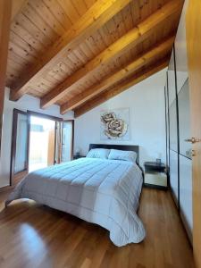 1 dormitorio con 1 cama grande y techo de madera en Stefano Apartments Padova Spacious,with parking, en Mestrino