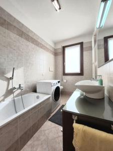 y baño con bañera y lavamanos. en Stefano Apartments Padova Spacious,with parking, en Mestrino