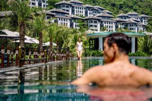 a man in the swimming pool at a resort at InterContinental Danang Sun Peninsula Resort, an IHG Hotel in Danang