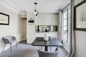 a kitchen with a table and chairs in a room at Magnifique appartement 4P- Musée du Louvre Tuileries in Paris