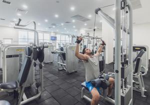 Ein Mann ist im Fitnessstudio und macht ein Training. in der Unterkunft Oak Sky Apartment Spa & Fitness in Skopje