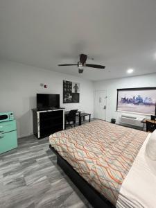 1 dormitorio con 1 cama, escritorio y TV en Grand Villa Inn Galleria en Houston