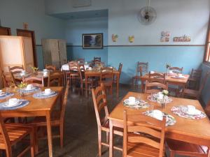 une salle à manger avec des tables et des chaises en bois dans l'établissement Recanto Caminho das Águas, à Caxambu