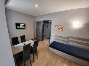 - une chambre avec un lit, une table et une télévision dans l'établissement Like Home on Zaliznychna 3, à Ivano-Frankivsk