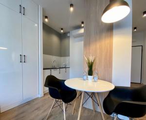 stół i krzesła w pokoju z kuchnią w obiekcie K22 Apart in Warsaw Slawinska 505 w Warszawie