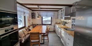 a kitchen with a wooden table and a couch at Haus am Sonnberg in Maria Alm am Steinernen Meer