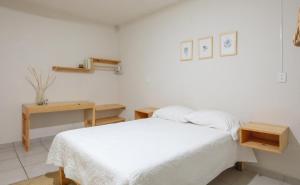 een witte slaapkamer met een bed en een bureau bij Casa Matia in Guadalajara