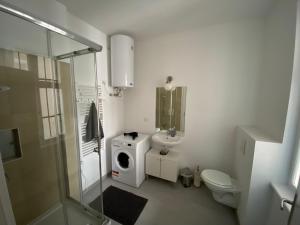 y baño con lavamanos y lavadora. en Vienna Living Apartments - Barnabitengasse, en Viena