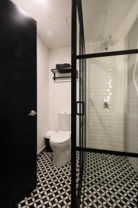 a bathroom with a toilet and a glass shower door at Hermoso y cómodo mini LOFT 3 in Mexico City